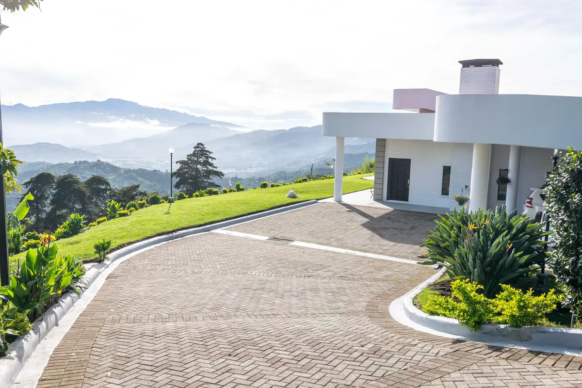 Front of the Pura Vida World home with its paved drive and mountain views